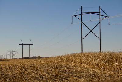 Wind turbines on field against clear sky