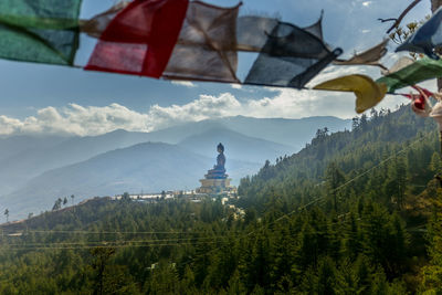 Prayer flags against buddha statue