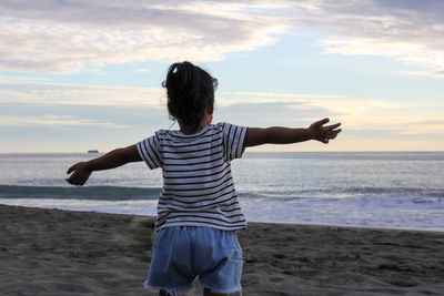 Rear view of woman standing on beach