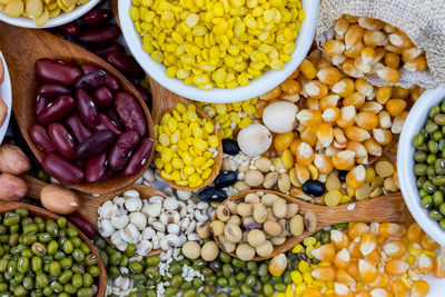 A variety of grains, such as black beans, red beans, dehydrated corn on white background.