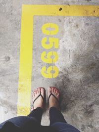 Female feet next to number on street