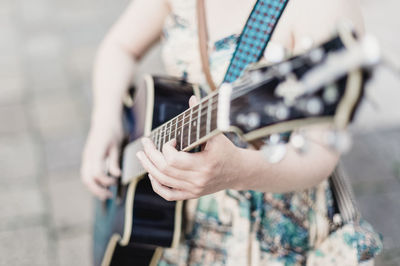 Midsection of man playing guitar