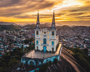 High angle view of buildings against cloudy sky at sunset