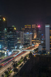 High angle view of illuminated street amidst buildings at night