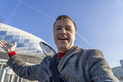 Portrait of young man standing against sky