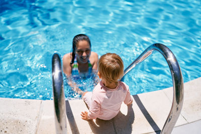 High angle view of woman looking at swimming pool