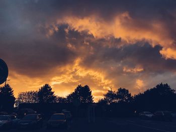 Cars on road against sky during sunset