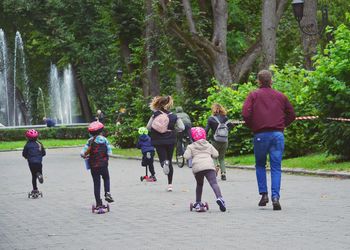 Rear view of people walking on footpath