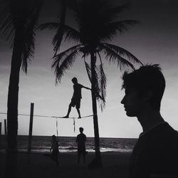 Silhouette people on beach at sunset