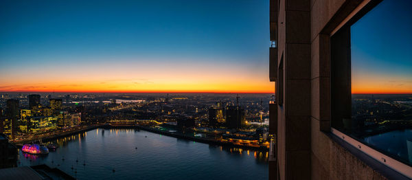 High angle view of illuminated bridge and buildings against sky at sunset