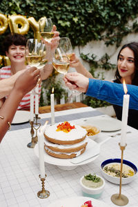 Cropped hands of friends toasting wines