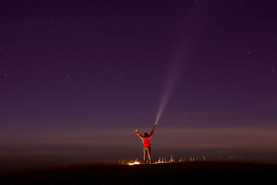 Low angle view of person standing on field against sky at night
