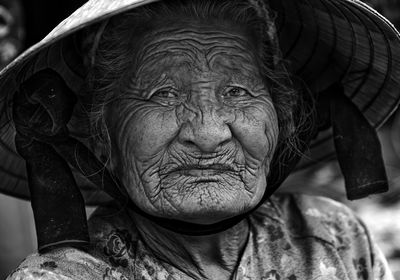 Close-up portrait of senior woman wearing conical hat