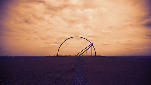 Ferris wheel against sky during sunset