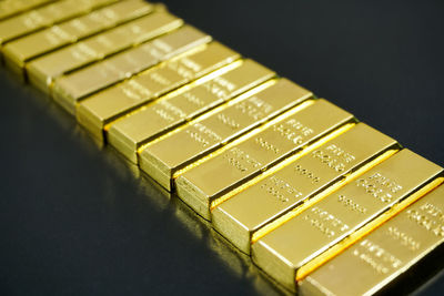 Close-up of gold bars in row on table