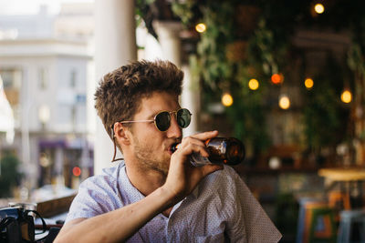 Young man drinking beer at restaurant