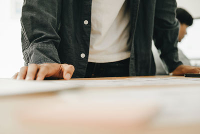 Midsection of man working on table