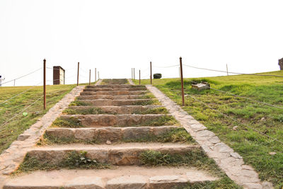 Staircase on field against clear sky