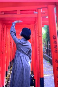 Rear view of woman standing against red wall　japanese sexygirl torii 