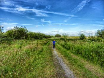 Full length rear view of woman standing on grassy field