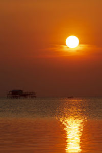 Scenic view of sea against orange sky