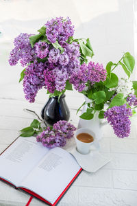 Midsection of woman with flowers on table