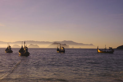 Boats sailing on sea against clear sky