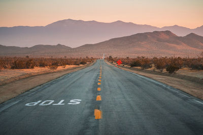 Road by mountains against clear sky