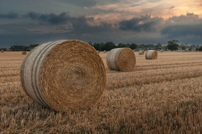 Hay bales on field against sky