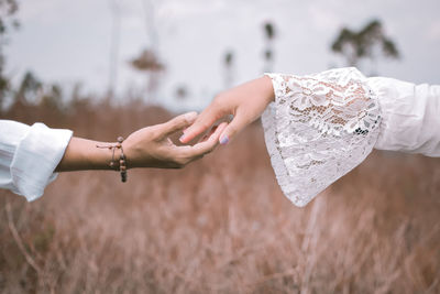 Midsection of couple holding hands