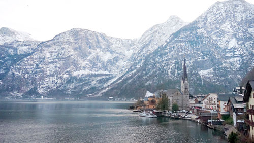 Scenic view of lake by snowcapped mountains against sky