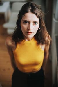 Portrait of young woman standing at home