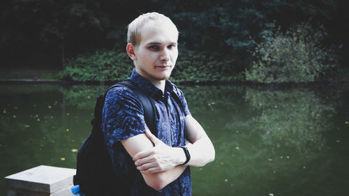 Portrait of young man standing against plants