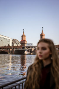 Portrait of woman with river in city