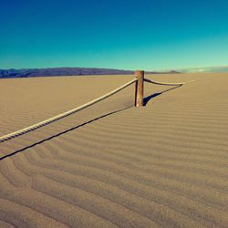 Scenic view of desert against clear blue sky