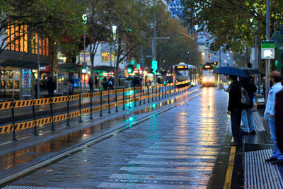 People and vehicles on city street in monsoon