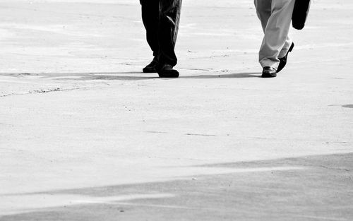 Low section of men walking on street