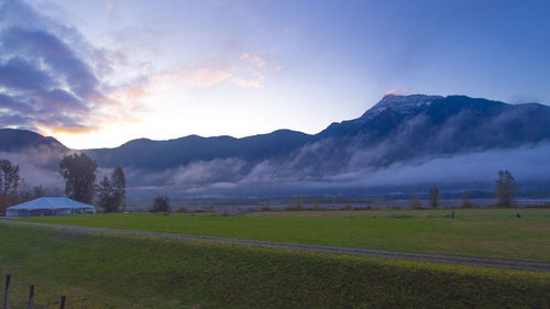 Scenic view of field against sky at sunset