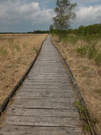 View of field against cloudy sky