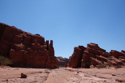 Rock formations in desert against clear blue sky