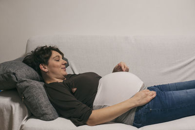 Pregnant woman on sofa at home