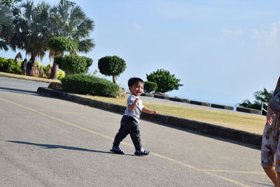 Full length of boy running on plant against sky