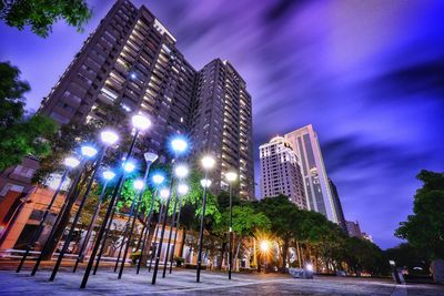 Low angle view of illuminated buildings against sky at night