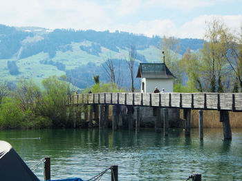 Built structure by lake against sky