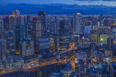 Aerial view of illuminated buildings in city against sky