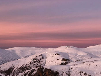 Scenic view of snowcapped mountains against sky during sunset