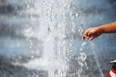 Cropped hand of boy at fountain