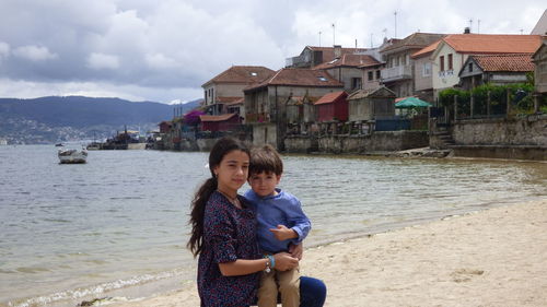 Portrait of girl with brother on shore at beach