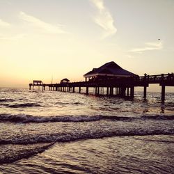 Pier on sea at sunset