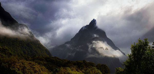 Scenic view of mountain half covered in mist.
